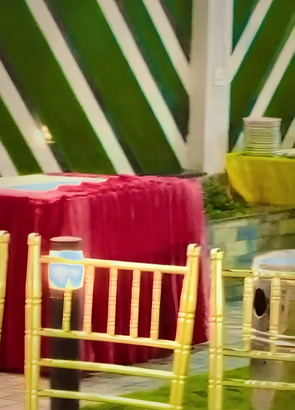 Red velvet tables and gold chairs under a tent